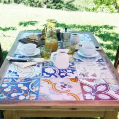 Tavolo con piastrelle fai da te, perfetto per un brunch all'aperto. Colori vivaci e motivi floreali creano un'atmosfera allegra.