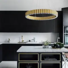 Cucina nera con pareti bianche, isola in marmo, lampadario dorato e sgabelli in pelle.