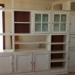 Mobile libreria decapato, con ante a vetro e vani a giorno. Il suo significato è un mobile con finitura effetto invecchiato.