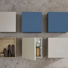 Composizione di pensili a muro: due blu, uno color corteccia con bottiglie, uno aperto con vasi, e due chiusi in tonalità neutre.