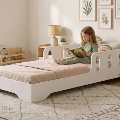 Bambina legge un libro nella sua cameretta neonato moderna, con peluche e quadri alle pareti.