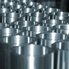 Dettaglio di cilindri metallici pronti per come cromare un metallo, con riflessi luminosi che ne esaltano la lucentezza.