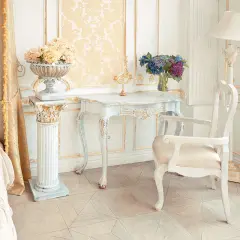 Camera da letto in stile provenzale francese, con letto, tavolino, sedia e decorazioni dorate.