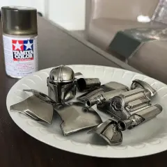 Vernice cromata spray Tamiya per plastica funziona. Pezzi di un elmo e armatura di un personaggio, come il Mandaloriano, pronti per essere assemblati.
