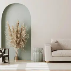 Un soggiorno moderno con divano e poltrona in tessuto color tortora chiaro, un vaso di pampas e un tavolino scanalato.