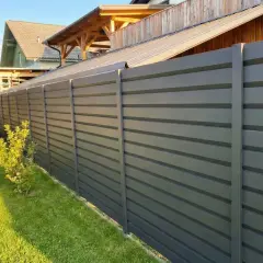 Moderna recinzione esterna grigia a listelli orizzontali, un'ottima idea per delimitare il giardino con stile e privacy.