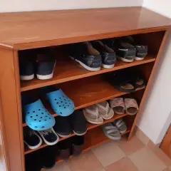 Scarpiera fai da te in legno, con scarpe da ginnastica, infradito e zoccoli blu.