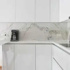Cucina moderna con mobili bianco lucido e piano in marmo. Si nota la differenza tra il bianco lucido e opaco.