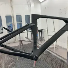 Telaio di bici in carbonio pronto per verniciare, in cabina di verniciatura.