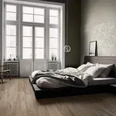 Camera da letto con parquet dai toni caldi, letto basso e pareti con texture floreale.