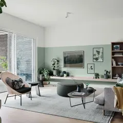 Soggiorno moderno con pareti bicolore, la parte inferiore dipinta in un rilassante verde salvia colore pareti, arredi minimalisti e piante.