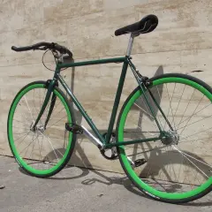 Bici da corsa verde con cerchi vivaci, un esempio di vernice per bici a pennello che risalta.