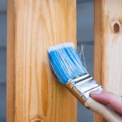 Pennello blu applica una finitura trasparente per riportare il legno al naturale, esaltandone le venature.