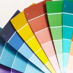 Ventaglio di campioni di colore, un tintometro manuale con sfumature vivaci dal blu al rosso, verde, arancione e giallo.