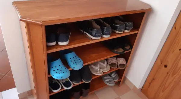 Scarpiera fai da te in legno, con scarpe da ginnastica, infradito e zoccoli blu.