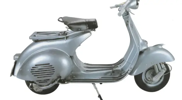 Vespa d'epoca color argento, con portapacchi e sella nera. La tabella colore originale Vespa da numero telaio è fondamentale per il restauro.