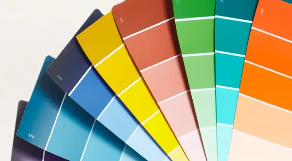 Ventaglio di campioni di colore, un tintometro manuale con sfumature vivaci dal blu al rosso, verde, arancione e giallo.