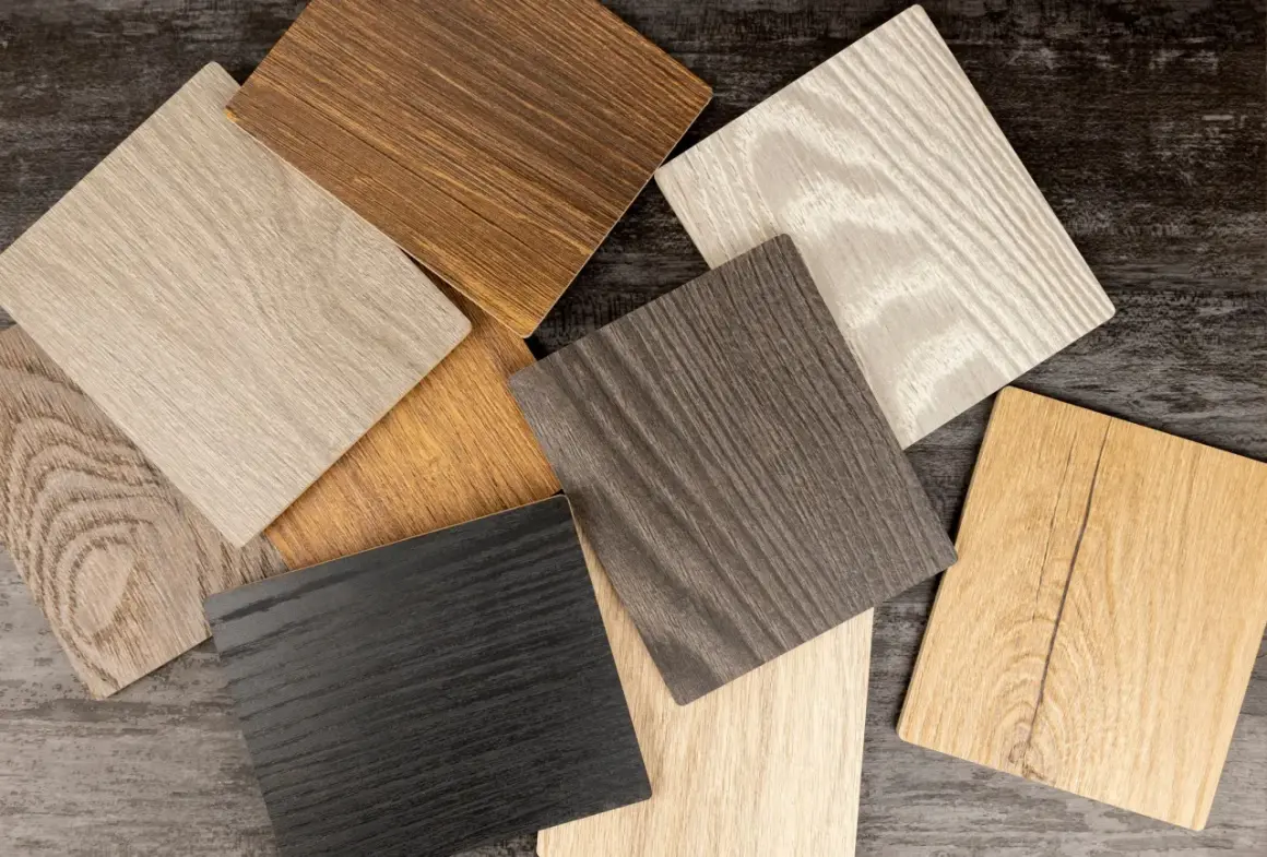 Campioni di finitura per legno in varie tonalità: dal nero al biondo, passando per grigi e marroni, con venature evidenti.