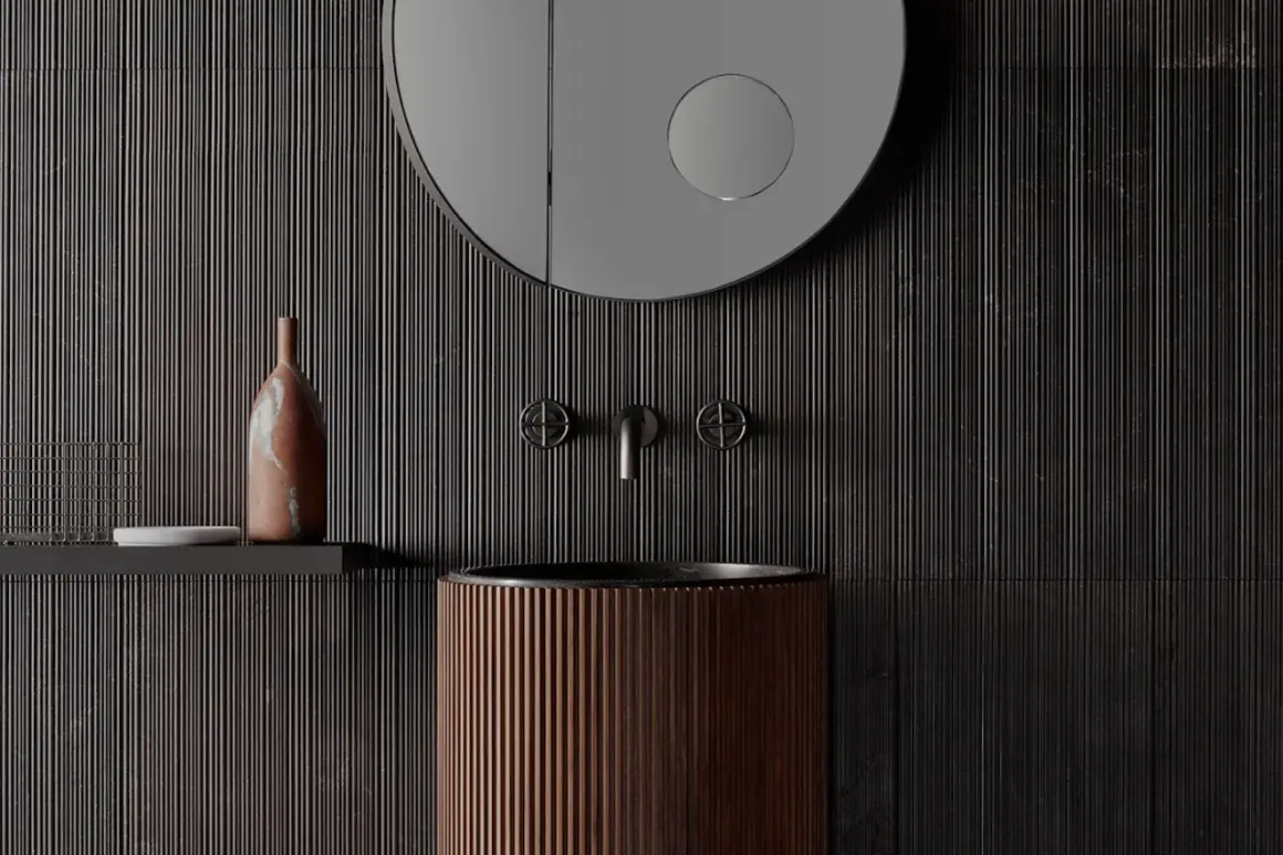Bagno moderno con lavabo in legno scanalato, rubinetteria in metallo scuro e specchio rotondo. Parete con un suggestivo effetto bambù.