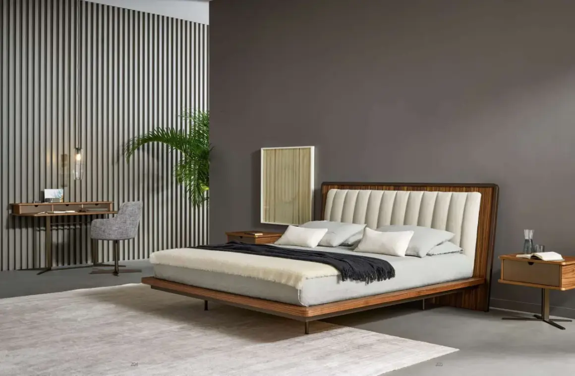 Elegante pittura camera da letto con letto moderno, scrivania e sedia grigia. Parete a righe verticali e pianta verde.