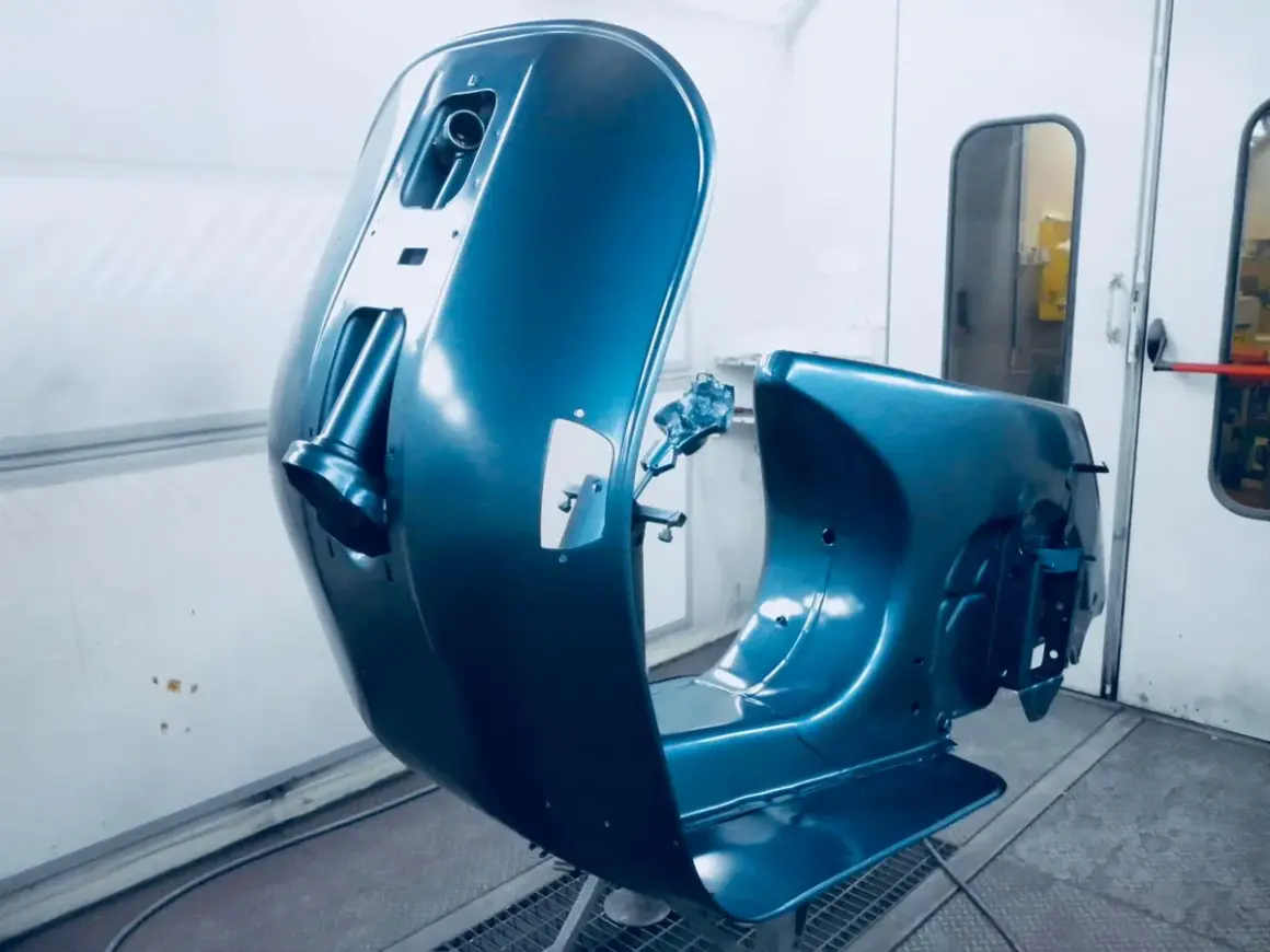 La carrozzeria di una Vespa, appena verniciata di blu metallizzato, pronta per essere rimontata. Un lavoro di verniciare Vespa senza sabbiare, per un risultato impeccabile.
