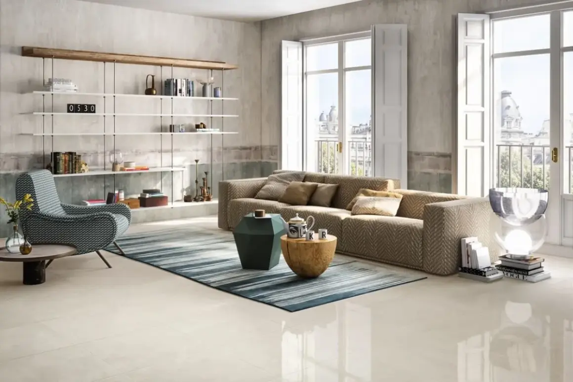 Salotto moderno con divano chevron, poltrona a zig-zag e scaffali bianchi. Pavimento in gres porcellanato color avorio.