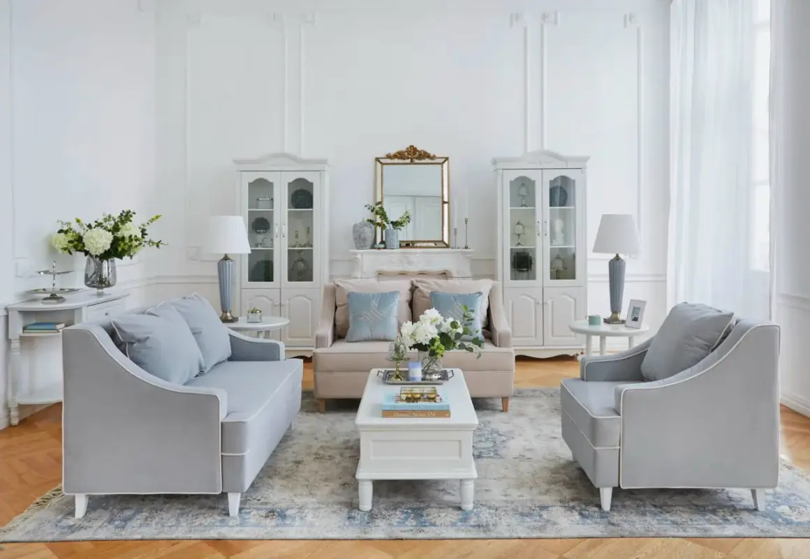 Salotto shabby chic: divani grigi, mobili bianchi, specchio dorato e fiori. Idee da copiare per un'atmosfera romantica.