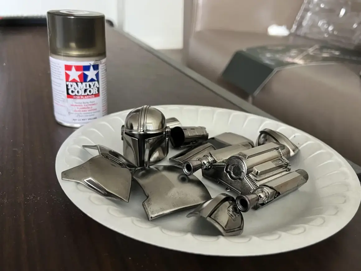Vernice cromata spray Tamiya per plastica funziona. Pezzi di un elmo e armatura di un personaggio, come il Mandaloriano, pronti per essere assemblati.