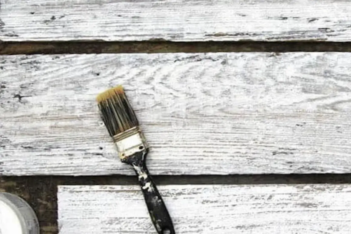 Pennello sporco su assi di legno verniciato con cementite, effetto shabby chic.