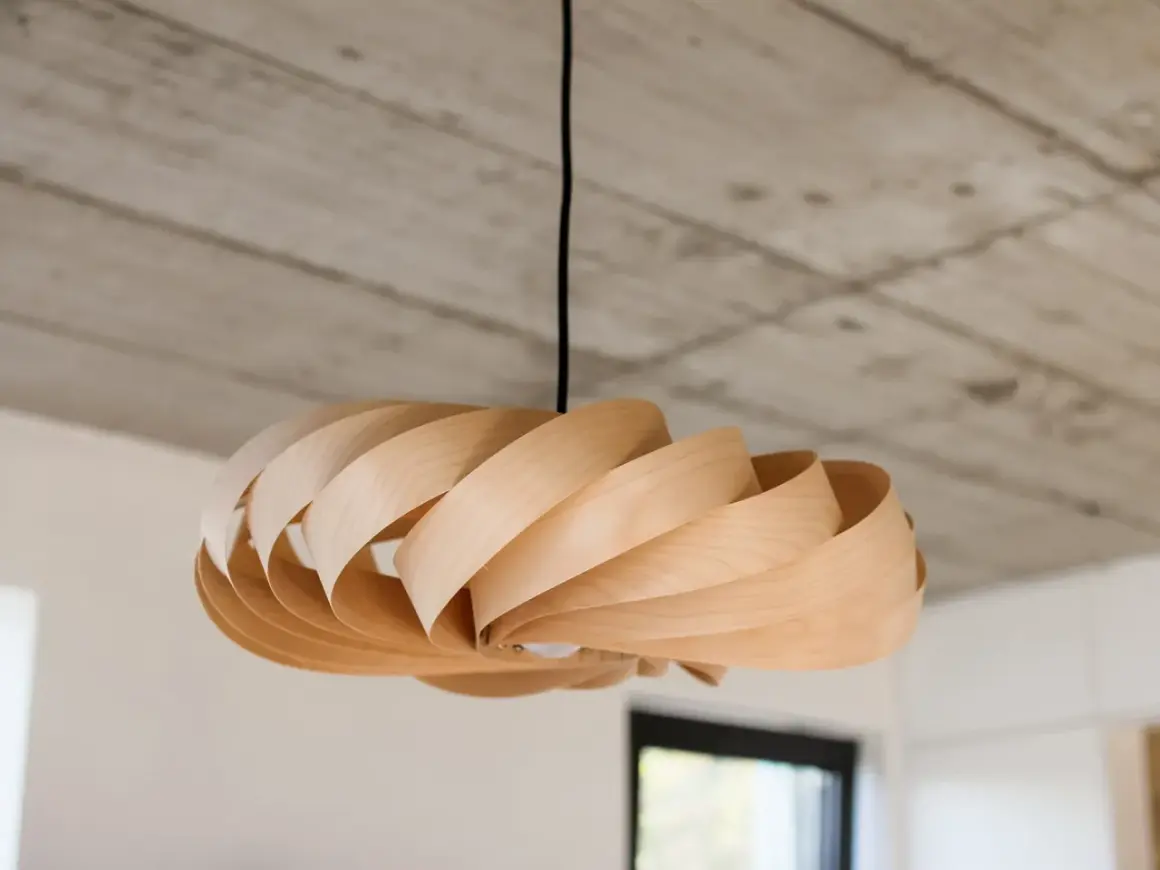 Lampada fai da te in legno, con lamelle curve che creano un effetto a spirale. Un pezzo unico che illumina con stile.