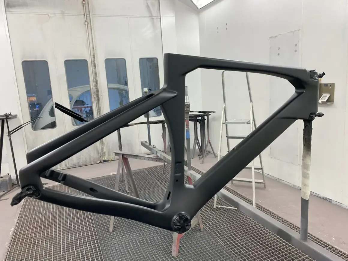 Telaio di bici in carbonio pronto per verniciare, in cabina di verniciatura.