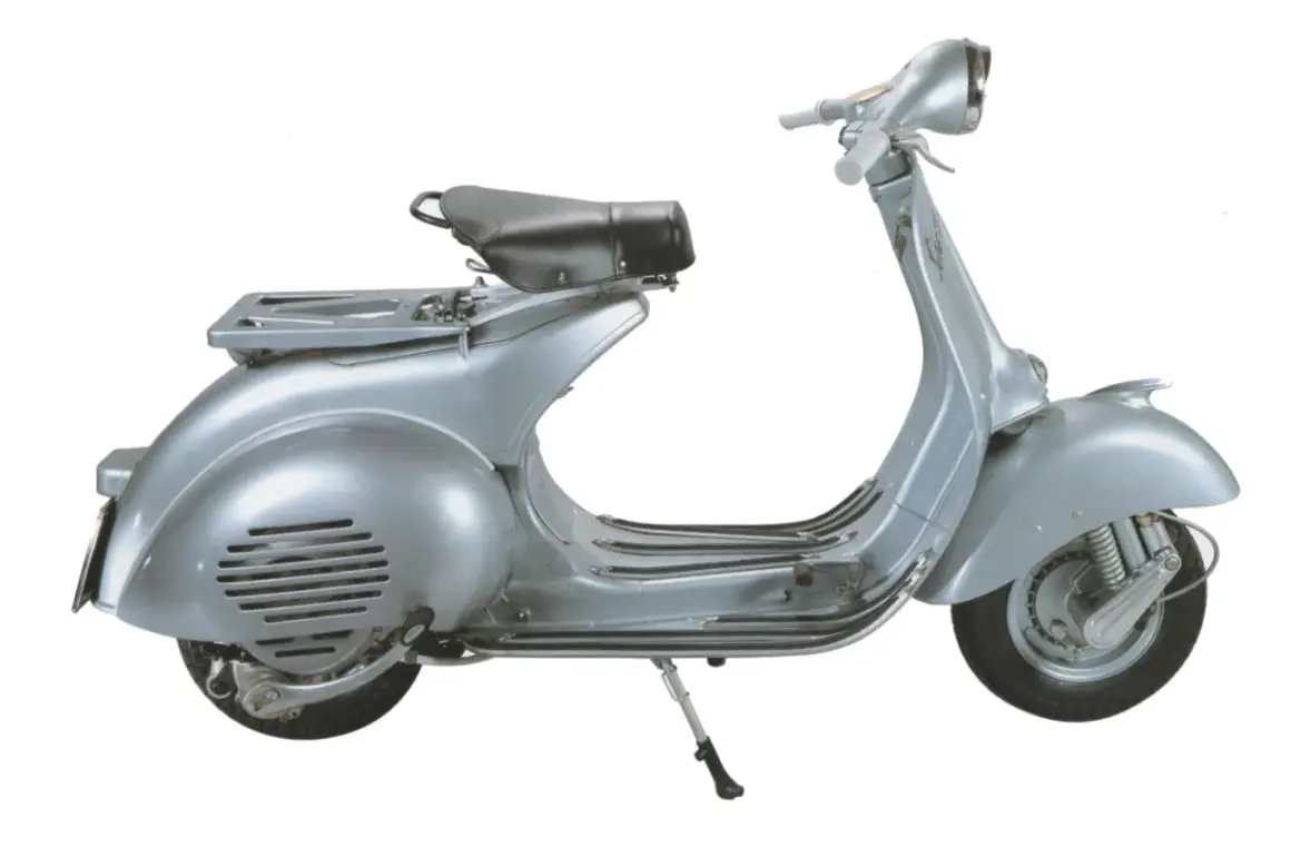 Vespa d'epoca color argento, con portapacchi e sella nera. La tabella colore originale Vespa da numero telaio è fondamentale per il restauro.