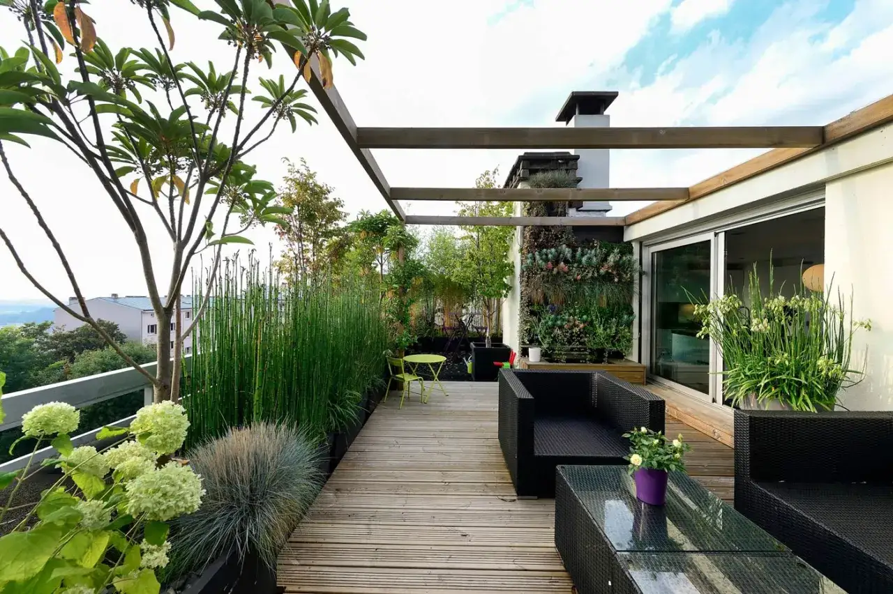 Arredare terrazzo con mobili neri, piante rigogliose e un giardino verticale. Un'oasi moderna per rilassarsi all'aperto.