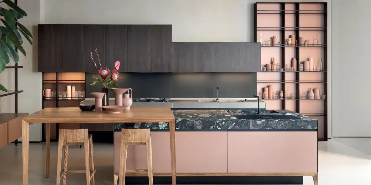 Cucina moderna con isola rosa cipria e piano in pietra. Pensili scuri e scaffalatura a vista con vasi, perfette idee pittura pareti cucina.