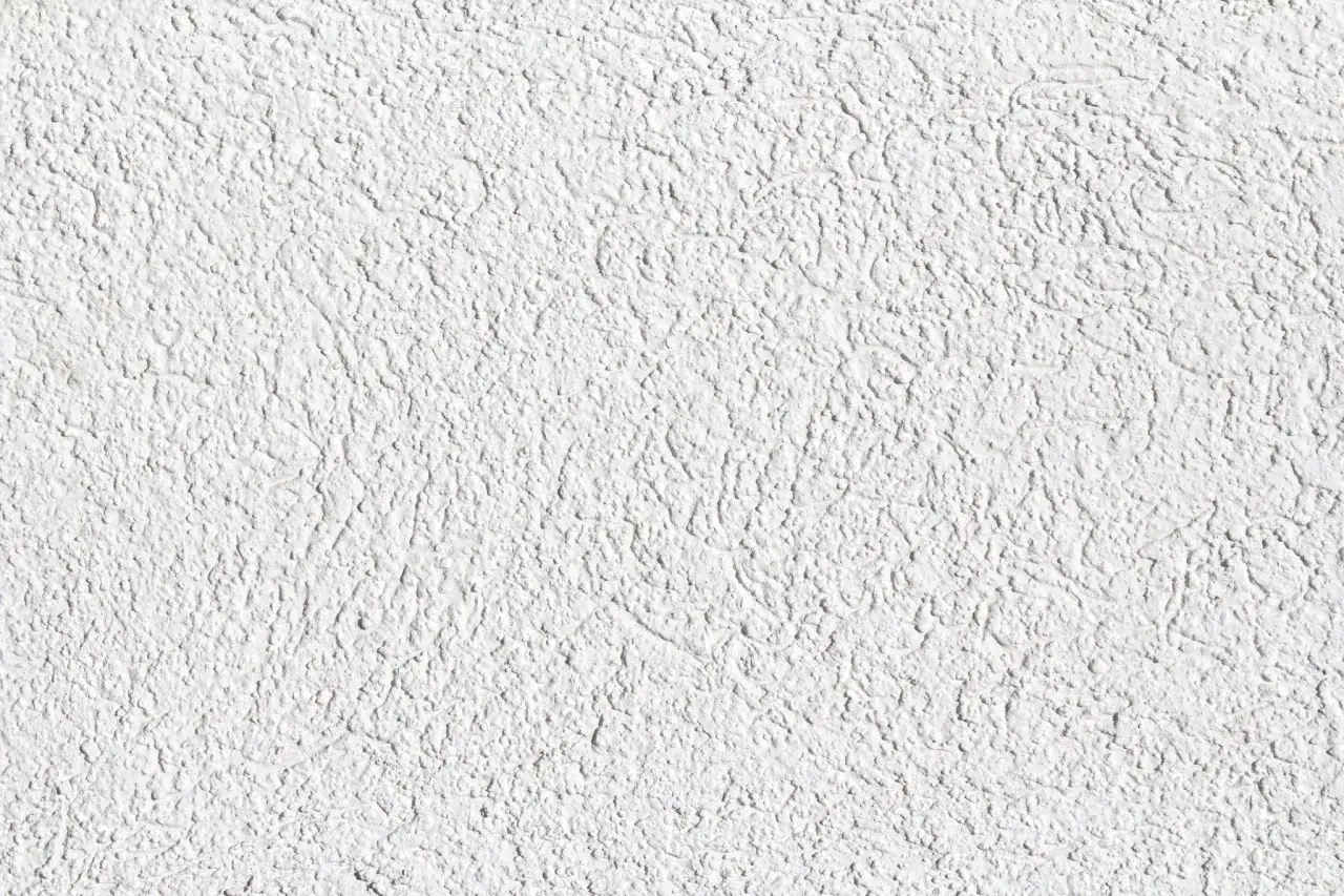Superficie ruvida e irregolare, con un'intensa texture che ricorda il color calce puro. Le ombreggiature creano un effetto tridimensionale.
