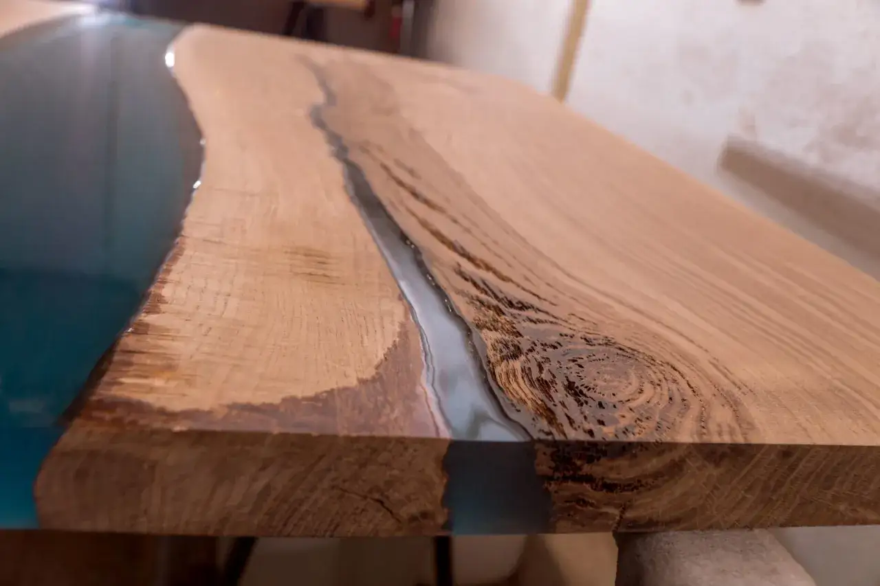 Superficie in legno con fiume di resina epossidica per legno come si usa. Dettaglio di un tavolo artigianale.
