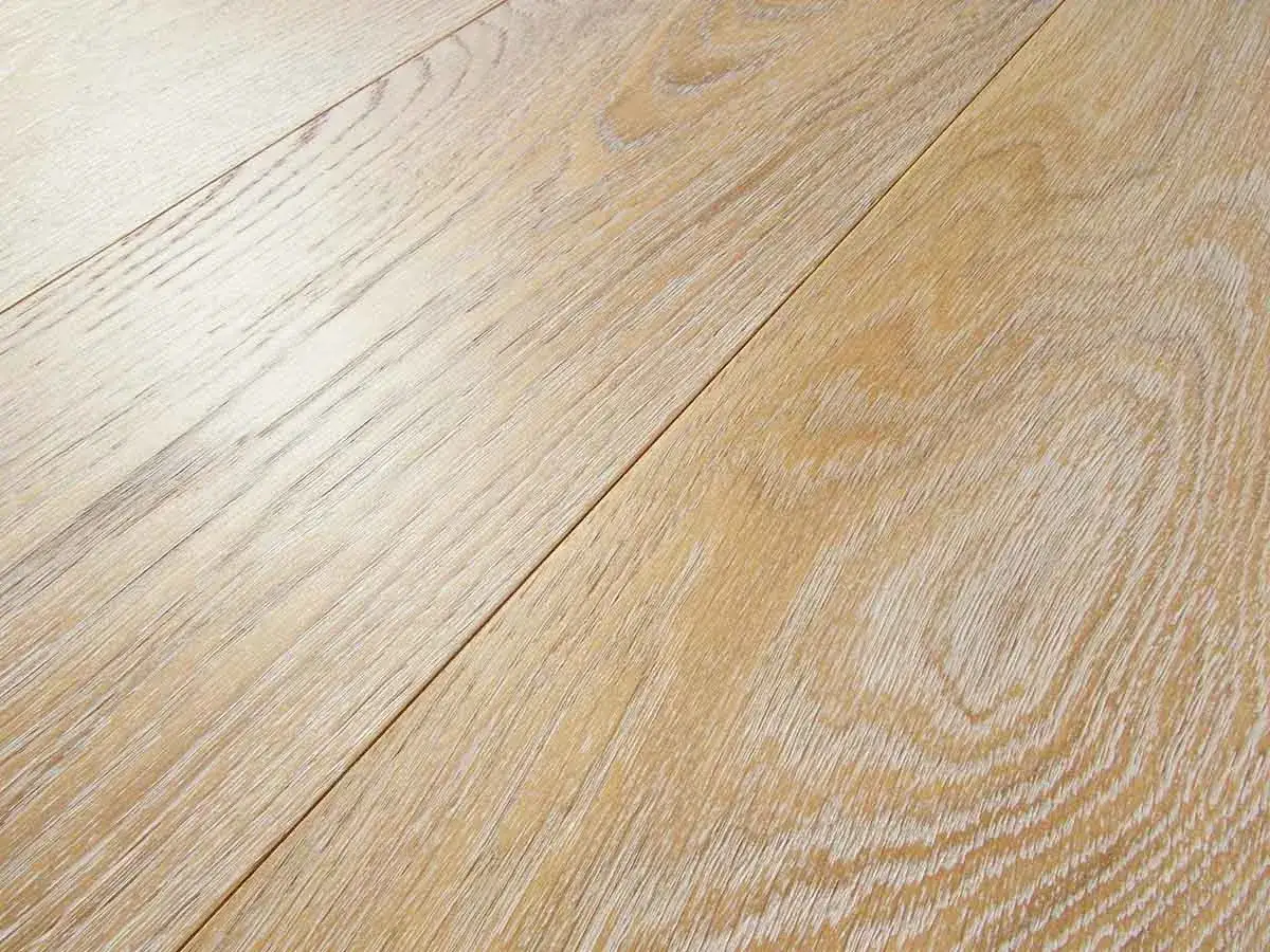 Superficie di tavole in legno decapato con venature chiare e texture naturale, che evocano un'atmosfera rustica e luminosa.
