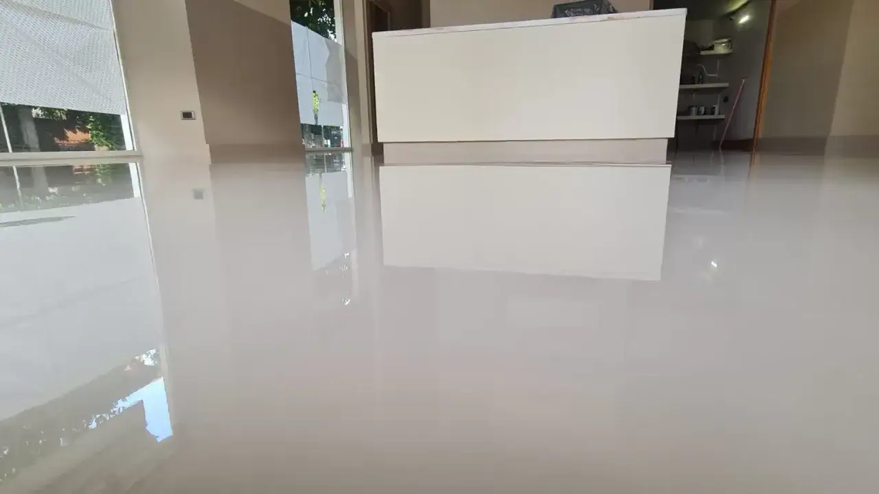 Pavimento lucido e riflettente, appena posato. Si percepisce l'odore pungente della resina, ricordando che respirare resina fa male.
