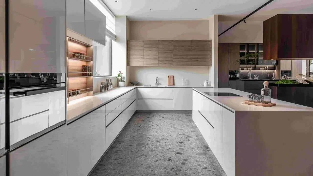Cucina moderna con mobili bianchi lucidi e un'isola centrale. Le pareti sono color avorio, creando un'atmosfera elegante e luminosa.