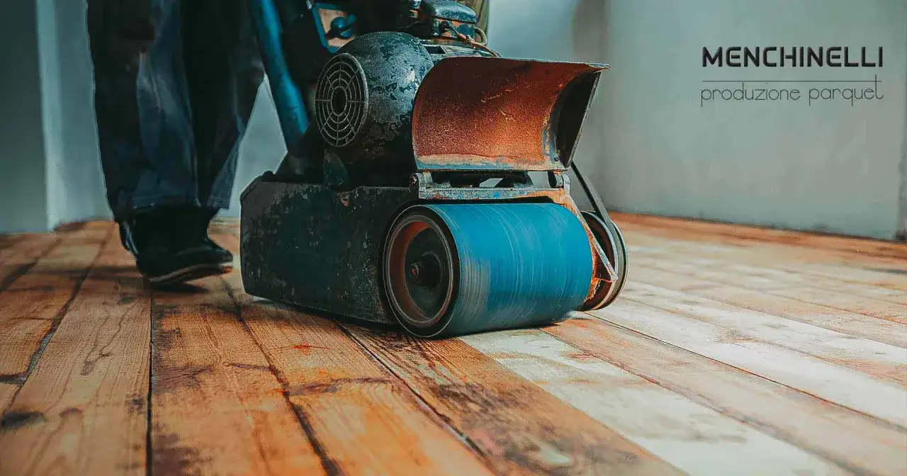 Lavoratore con levigatrice per parquet, la lamatura meccanica restituisce lucentezza al legno.