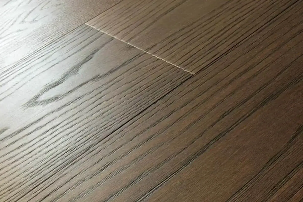 Dettaglio di un pavimento in legno con venature scure e chiare, che esaltano i naturali colori legno.