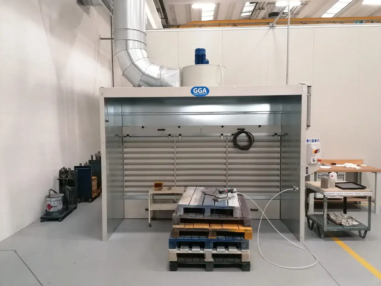Cabina di verniciatura con sistema di aspirazione solventi vernici, dotata di aspiratore e filtri.