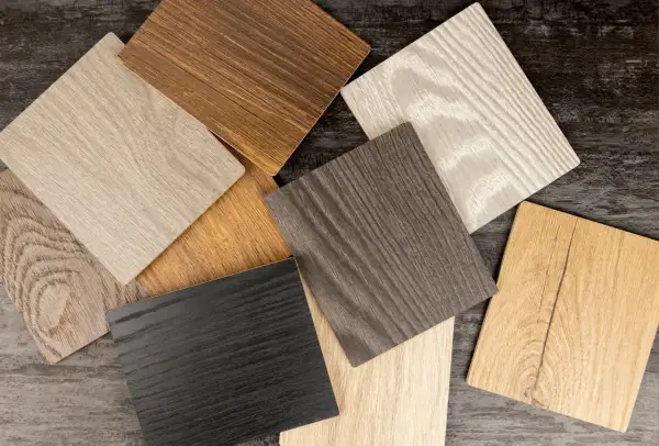 Campioni di finitura per legno in varie tonalità: dal nero al biondo, passando per grigi e marroni, con venature evidenti.