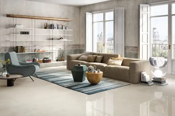 Salotto moderno con divano chevron, poltrona a zig-zag e scaffali bianchi. Pavimento in gres porcellanato color avorio.