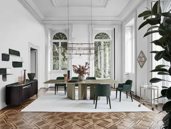 Sala da pranzo con tavolo e sedie in stile mid century modern, illuminata da un lampadario a sfere e con un mobile basso in legno scuro.