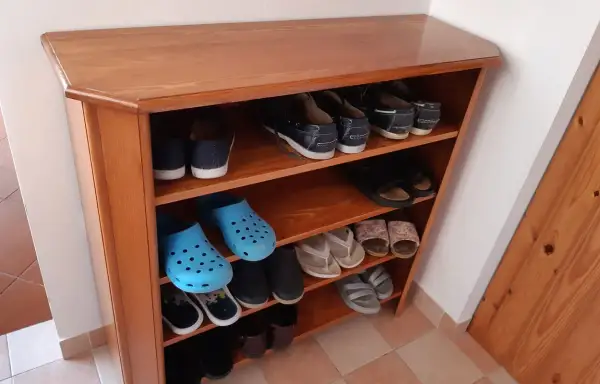 Scarpiera fai da te in legno, con scarpe da ginnastica, infradito e zoccoli blu.