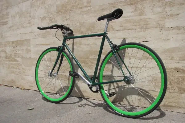 Bici da corsa verde con cerchi vivaci, un esempio di vernice per bici a pennello che risalta.