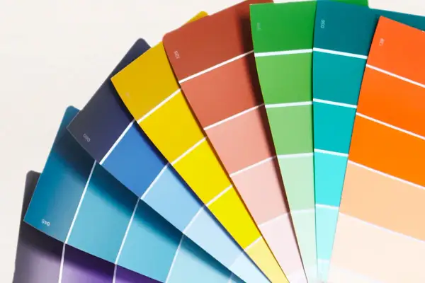Ventaglio di campioni di colore, un tintometro manuale con sfumature vivaci dal blu al rosso, verde, arancione e giallo.